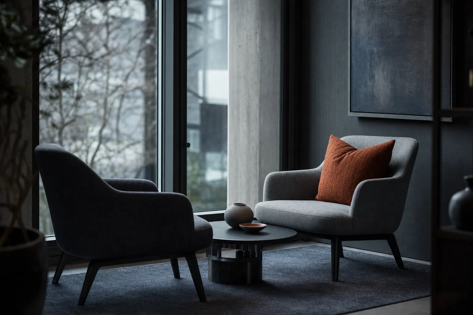 Two armchairs around a low table in a quiet office corner — a conversation, not a pitch
